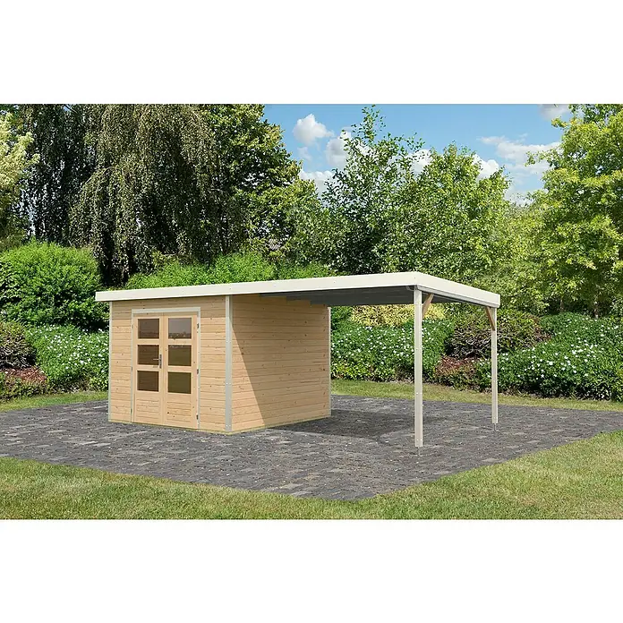 Karibu Gartenhaus Pluto 6 A - Außenmaß inkl. Dachüberstand (B x T): 595,5 x 292,4 cm, Fichte/ Metall, Naturbelassen/ Weiß - Ein Holzgartenhaus mit einem Anbau mit einem Flachdach in einer grünen Umgebung. Das Gartenhaus hat doppelte Glastüren.