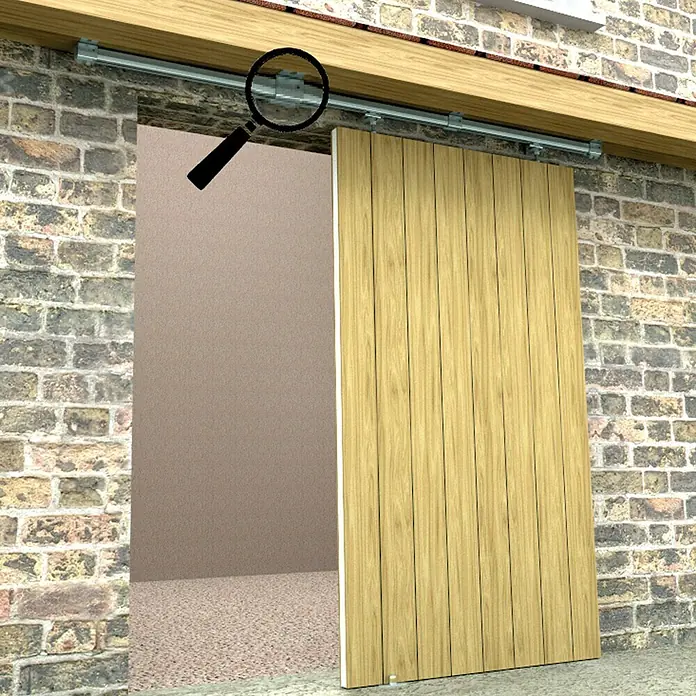 HBS Betz Schiebetorbeschlag-Komplettset Typ 30 - 200 cm, Traglast: 180 kg, Deckenmontage, Einsatzbereich: Stallungen - Schiebetürbeschlag aus Metall mit einer Holztür, die vor einer Ziegelwand montiert ist. Die Tür kann entlang der Schiene gleiten.