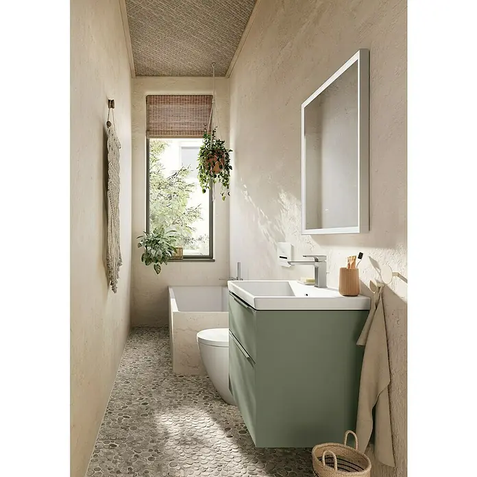 Villeroy & Boch Subway 3.0 Waschbeckenunterschrank - Soft Green, Anzahl Schubladen: 2 Stk., Farbe Griff: Aluminium glänzend, 62,2 x 47,8 x 57,6 cm - Ein Badezimmer mit einem grünen Waschtisch mit Schubladen, einem weißen Waschbecken und einem großen Spiegel an der Wand.