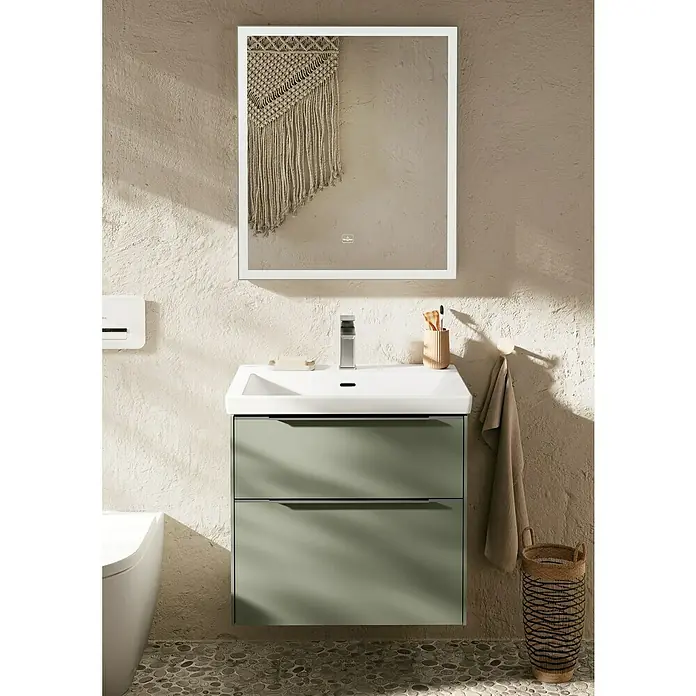 Villeroy & Boch Subway 3.0 Waschbeckenunterschrank - Soft Green, Anzahl Schubladen: 2 Stk., Farbe Griff: Aluminium glänzend, 62,2 x 47,8 x 57,6 cm - Ein modernes Badezimmer mit einem stilvollen Unterschrank in Grün und einem beleuchteten Spiegel mit Deko.