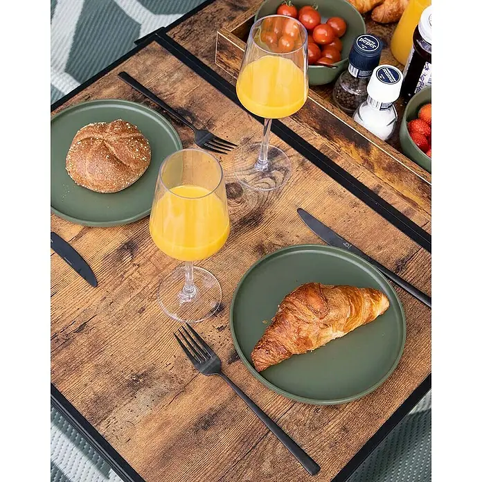 Bo-Camp Campingtisch Industrial - L x B x H: 90 x 60 x 81 cm, Aluminium/MDF, Schwarz/Braun - Ein Frühstückstisch mit Brötchen, Croissant, Orangensaft und Gewürzen auf einem Holztisch.