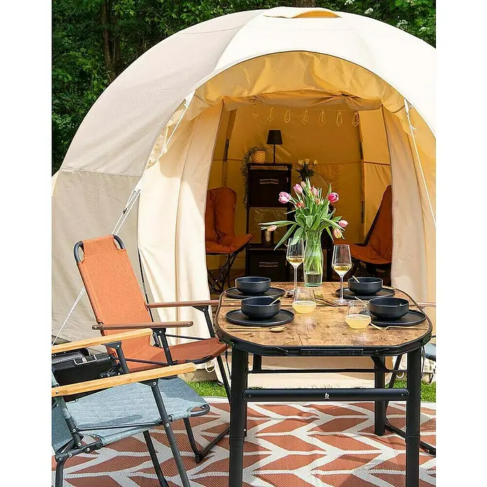 Bo-Camp Campingstuhl Bushwick M - Aluminium, Bambus, Orange, B x T x H: 52 x 60 x 90 cm - Ein gemütliches Outdoor-Dinner-Setup mit einem Campingtisch, Stühlen und Geschirr vor einem Zelt.