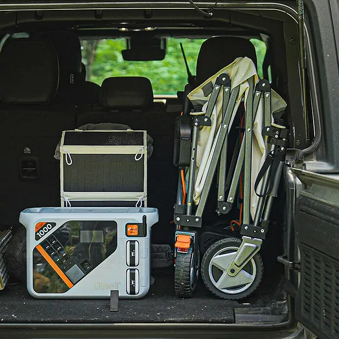 Litheli Bollerwagen 450 W W1 Pro EHW030005 -  - Eine graue Lithell Eclair 1000 Powerstation und ein zusammengeklappter Bollerwagen im Kofferraum eines Autos.