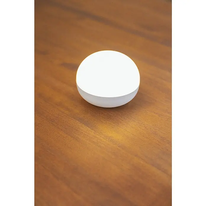 New Garden LED-Poolbeleuchtung Coco Floating Blulb - Durchmesser: 11 cm, Weiß, LED - Minimalistische Ansicht einer modernen, kugelförmigen Tischleuchte auf einer Holzoberfläche, die warmes Licht ausstrahlt und eine gemütliche Atmosphäre schafft.