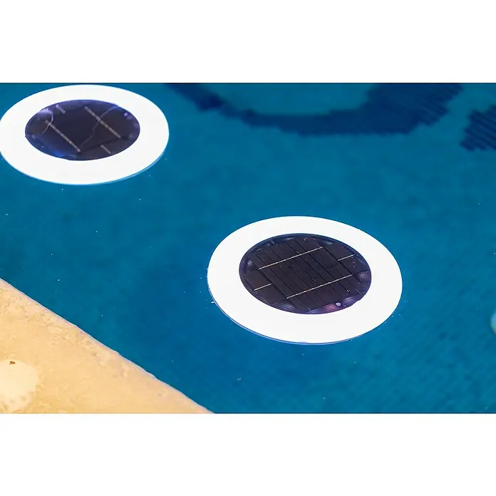 New Garden LED-Poolbeleuchtung Papaya - Durchmesser: 29 cm, Weiß - Zwei runde, weiße Solarleuchten schwimmen auf einem türkisfarbenen Pool und laden sich auf.