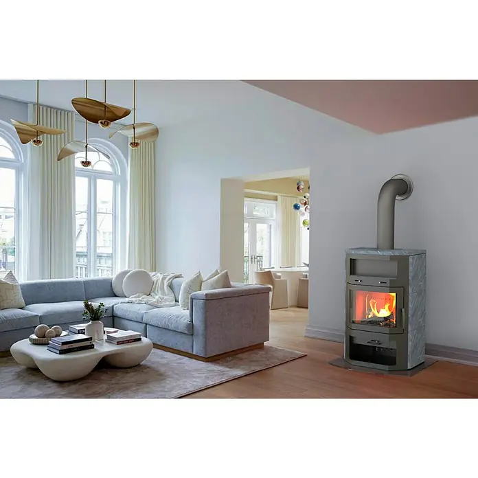 Kaminofen Bali Max - 8,5 kW, Raumheizvermögen: 244 m³, Verkleidung: Naturstein, Grau - Das Bild zeigt ein modernes Wohnzimmer mit einem stilvollen Kaminofen als zentralem Element. Der Kaminofen sorgt für Wärme und Atmosphäre im Raum.
