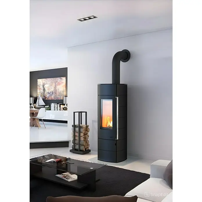 Kaminofen Alpha Ring - 6 kW, Raumheizvermögen: 172 m³, Material Verkleidung: Stahl, Farbe Verkleidung: Schwarz - Ein moderner Kaminofen in Schwarz mit Holzscheitlager in einem stilvollen Wohnzimmer. Das elegante Design fügt sich nahtlos in das Interieur ein.