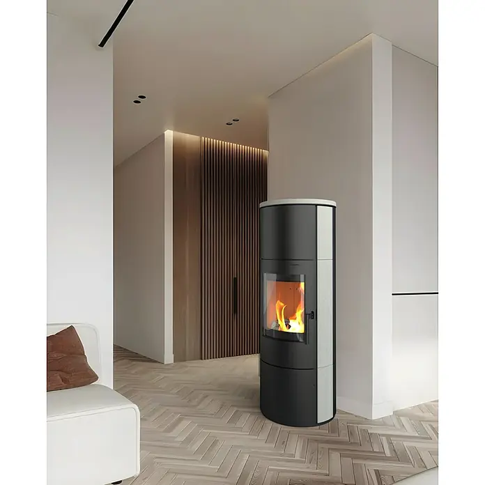 Kaminofen Cumulus Omega XL Limestone - 7 kW, Raumheizvermögen: 200 m³, Schwarz - Ein moderner Kaminofen in einem stilvollen Wohnraum, der Wärme und Eleganz vereint. Der Ofen steht auf einem hellen Holzboden und ist ein Blickfang.