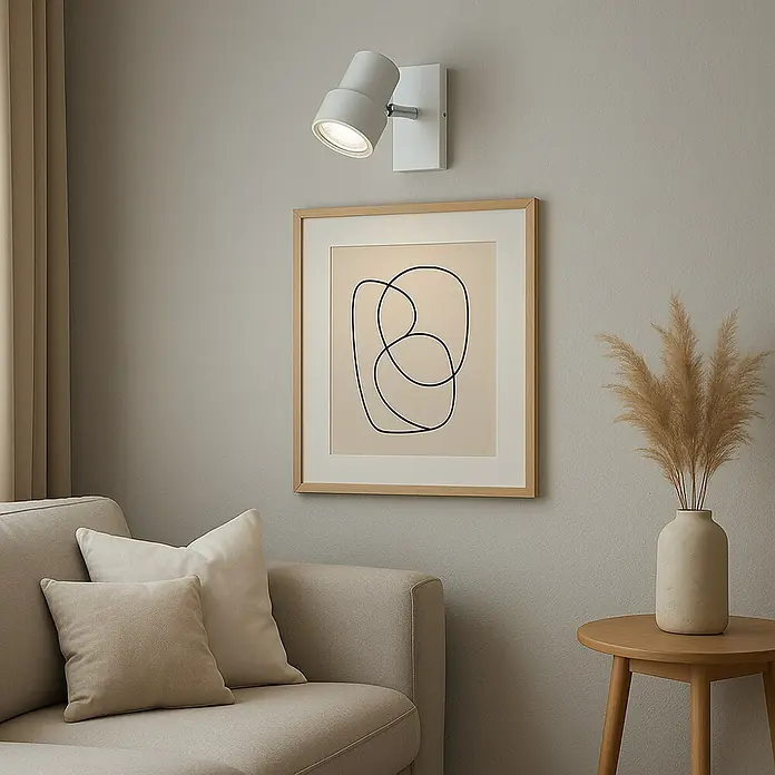Briloner Foco de pared LED Rock - 5 W, L x An x Al: 80 x 120 x 120 mm, Blanco, Blanco cálido - Primer plano de una lámpara de pared sobre una obra de arte enmarcada, destacando una estética de espacio habitable moderno.