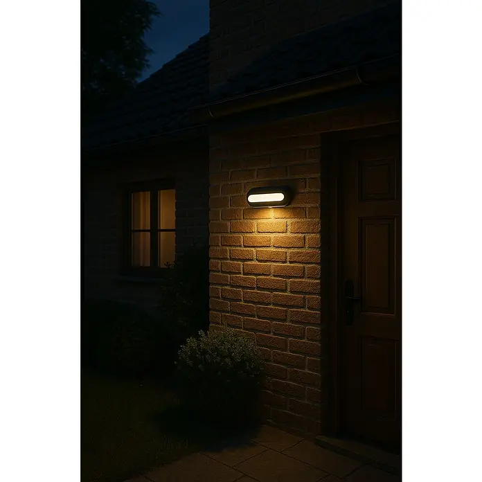 Lavida Solar-Außenwandleuchte - 5 W, L x B x H: 25 x 12 x 6,5 cm, Schwarz, IP54, 500 lm - Eine ovale Wandleuchte mit LED-Beleuchtung an einer Backsteinmauer neben einer Haustür.