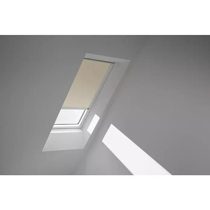 Velux Dachfensterrollo DSL M04 1085KWL - Farbe: Beige - 1085KWL, Farbe Schiene: Weiß, Solarbetrieben - Ein Dachfenster mit einem beigen Rollo, das teilweise geschlossen ist, um das Licht zu dimmen und Privatsphäre zu schaffen. Das Fenster ist in eine weiße Decke eingelassen.