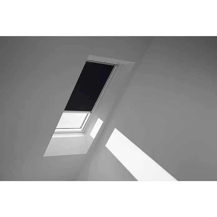 Velux Dachfensterrollo DSL F04 3009K - Farbe: Schwarz - 3009K, Farbe Schiene: Aluminium, Solarbetrieben - Blick auf ein Dachfenster mit Rollo, das teilweise geschlossen ist und Licht in den Raum lässt. Das Rollo ist schwarz und das Fenster ist weiß.