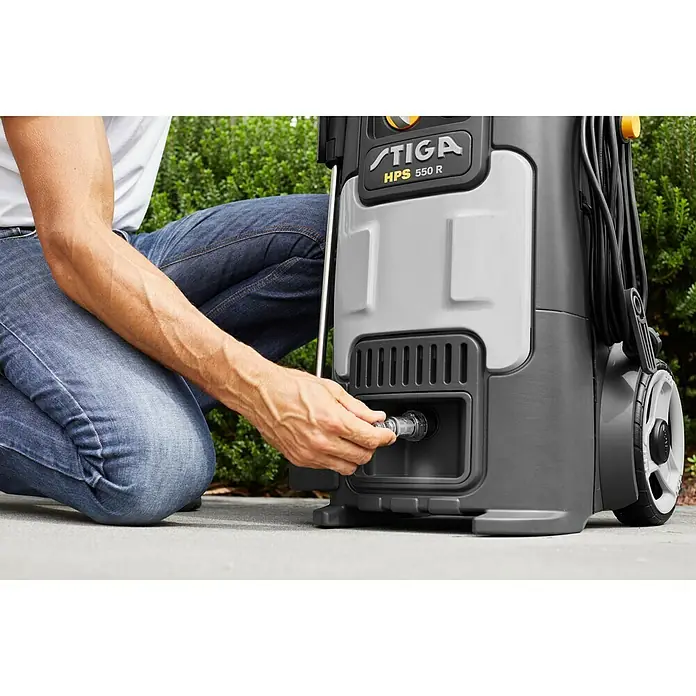Stiga Hochdruckreiniger HPS 550 R - 2.500 W - Ein Mann schliesst den Stiga HPS 550 R Hochdruckreiniger an. Perfekt für die Reinigung von Aussenbereichen, mit praktischen Aufbewahrungsmöglichkeiten.