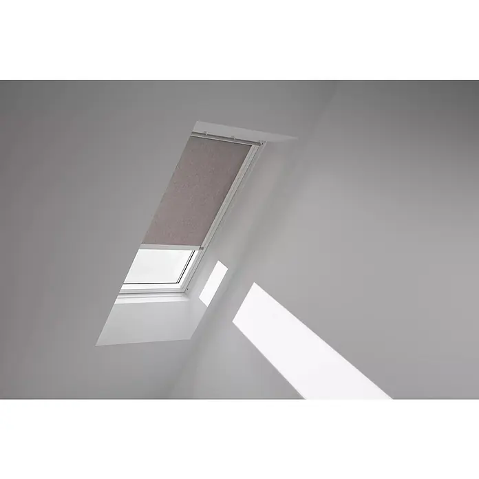 Velux Dachfensterrollo RML MK04 4167KWL - Farbe: Taupe - 4167KWL, Farbe Schiene: Weiß, Elektrisch - Das Bild zeigt ein Dachfenster mit einem Rollo, das teilweise heruntergelassen ist, in einem hellen, modernen Raum.