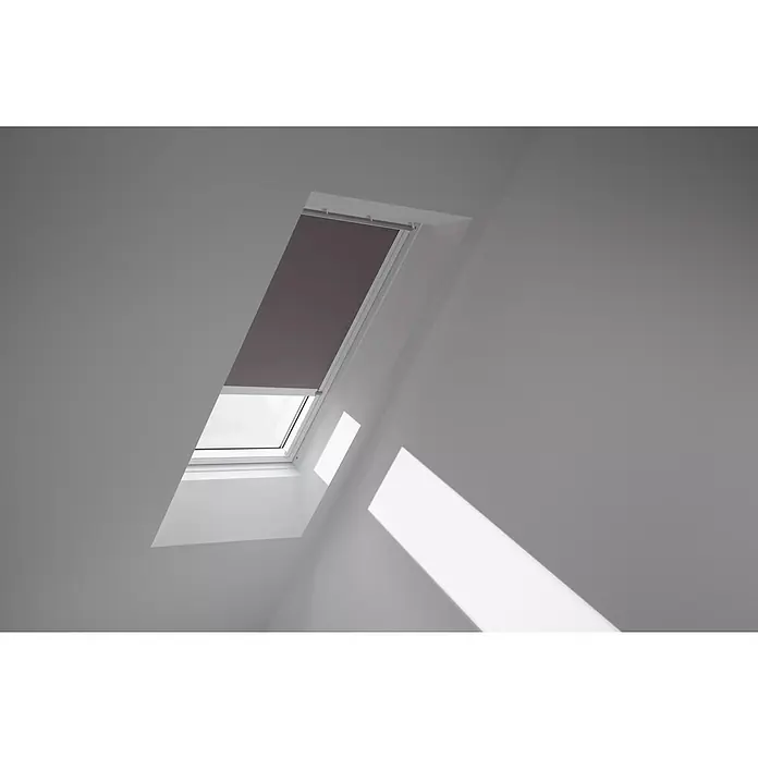 Velux Dachfensterrollo DML SK08 4577KWL - Farbe: Taupe - 4577KWL, Farbe Schiene: Weiß, Elektrisch - Dachfenster mit Verdunkelungsrollo teilweise geschlossen, das Licht scheint ins Zimmer. Optimaler Sonnenschutz für Ihr Zuhause.