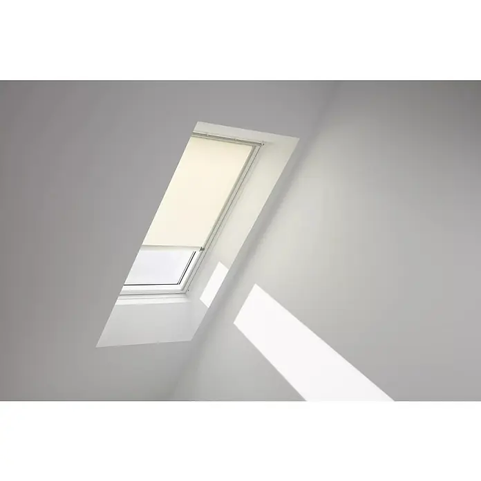 Velux Dachfensterrollo RSL MK12 1086K - Farbe: Hellbeige - 1086K, Farbe Schiene: Aluminium, Solarbetrieben - Helles Dachfenster mit Rollo in einem schrägen weißen Raum, das Licht hereinlässt. Das Fenster sorgt für eine natürliche Beleuchtung.