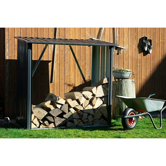 Dobar Kaminholzregal Madera - 163 x 83 x 154 cm, Metall, Metallic - Brennholzregal gefüllt mit Holzscheiten im Garten, daneben eine Schubkarre und ein Holzschemel mit Blumenarrangement.