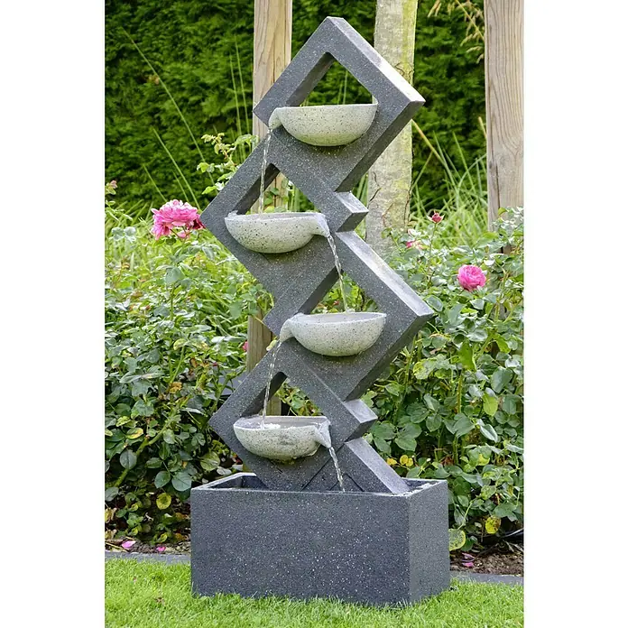 Dobar Kunststeinbrunnen - 41,5 x 20,5 x 100,5 cm - Moderne Gartenbrunnen mit vier Schalen und Wasserlauf, umgeben von Blumen und Grün, sorgt für eine entspannende Atmosphäre im Garten.