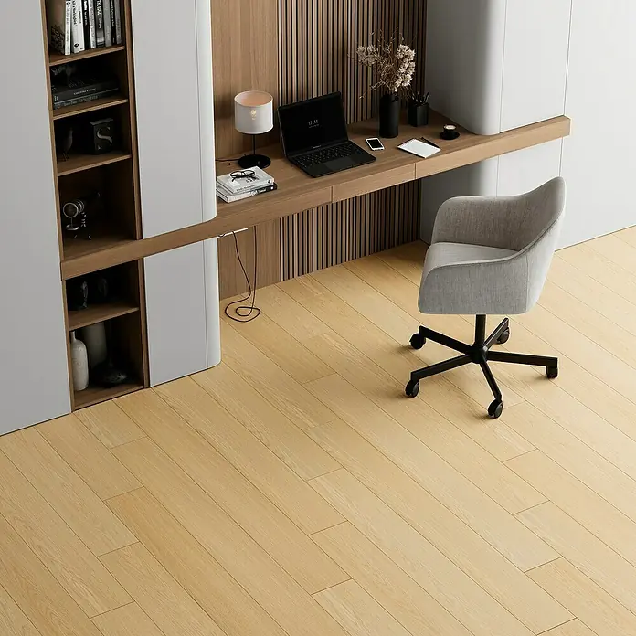 Suelo vinílico SPC Coimbra - 1.520 x 180 x 5,5 mm, Beige, Resistente al agua - Una silla de oficina gris claro con base negra se ubica sobre un piso de madera clara frente a un escritorio moderno con un ordenador portátil y una lámpara.