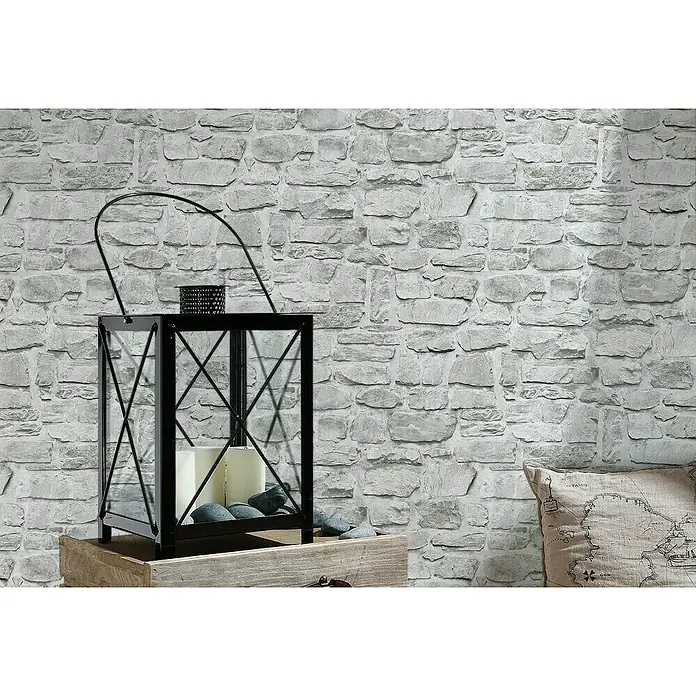 A.S. Création Il Decoro Vliestapete Steine - Beige/Grau, Steinoptik, 10,05 x 0,53 m - Kerzenlaterne: Eine stilvolle, schwarze Laterne mit Kerzen und dekorativen Steinen, perfekt für eine gemütliche Atmosphäre in jedem Raum.
