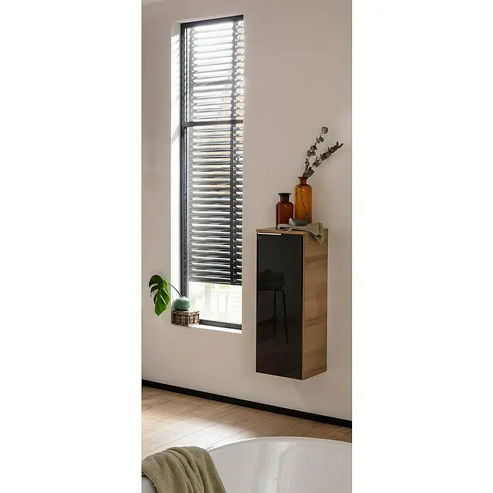 Fackelmann B.brillant Midischrank - B x T x H: 30,2 x 32 x 82,6 cm, Anthrazit - Das Bild zeigt ein Badezimmer mit einem modernen Hängeschrank in Holzoptik und schwarzer Glasfront, dekoriert mit Vasen und Pflanzen.
