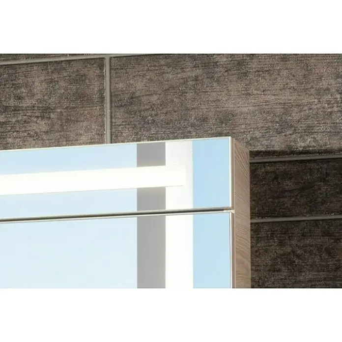 Fackelmann B.clever LED-Spiegelschrank - B x H: 120 x 70,6 cm, Holzoptik Alaska Esche, Anzahl Türen: 2 Stk. - Nahaufnahme eines Spiegelschranks mit integrierter Beleuchtung vor einer strukturierten Wand.