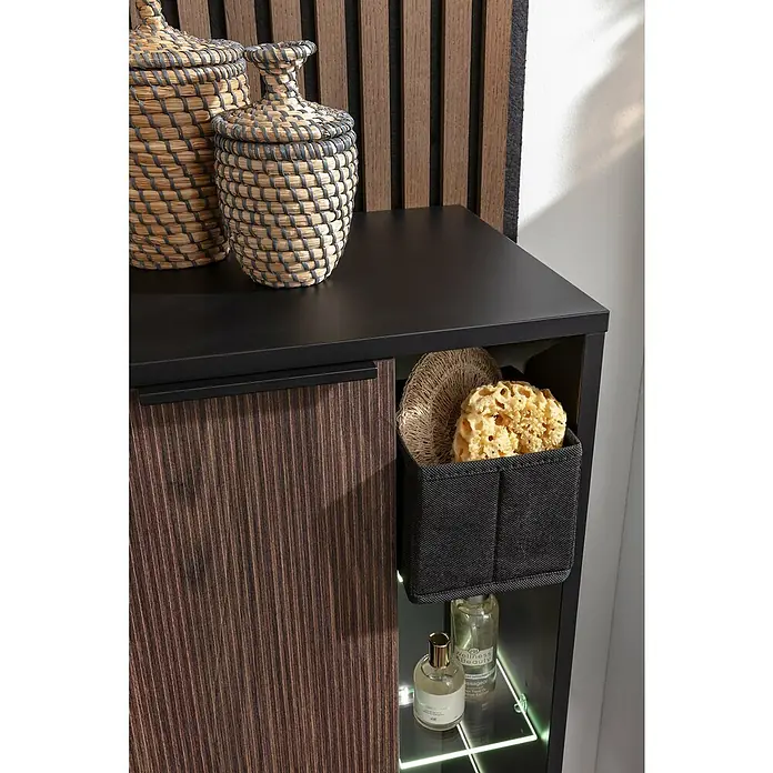 Fackelmann B.Paris Midischrank - B x T x H: 47 x 32 x 84,2 cm, Anschlag: Links, Rigoletto - Stilvolles Badezimmer-Ensemble: Geflochtene Körbe auf schwarzer Kommode, Ablage mit Schwamm und Lotionen, akzentuiert durch moderne Beleuchtung.