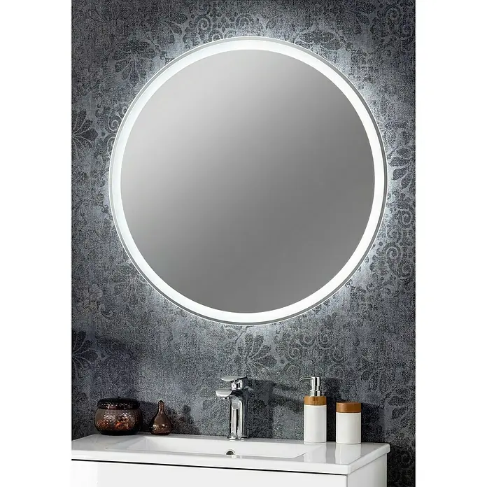 Fackelmann Lichtspiegel Mirror - Durchmesser: 80 cm, umlaufende LED-Beleuchtung - Ein runder, beleuchteter Badezimmerspiegel hängt über einem weißen Waschtisch mit Armatur und Dekorationen, vor einer gemusterten Wand.