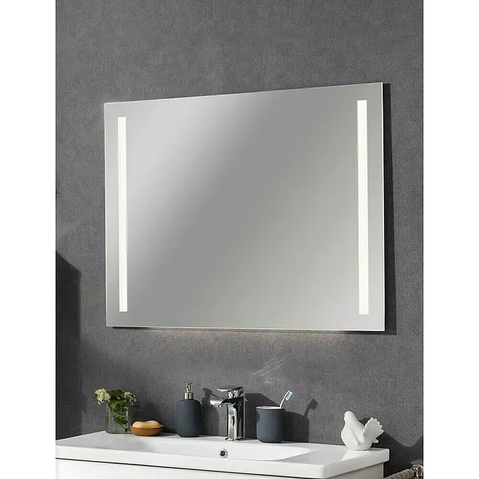 Fackelmann Lichtspiegel Mirror - B x H: 100 x 75 cm, Sensorschalter, Ambientebeleuchtung - Das Bild zeigt einen rechteckigen Badezimmerspiegel mit integrierter LED-Beleuchtung, der über einem Waschbecken an einer grauen Wand montiert ist.