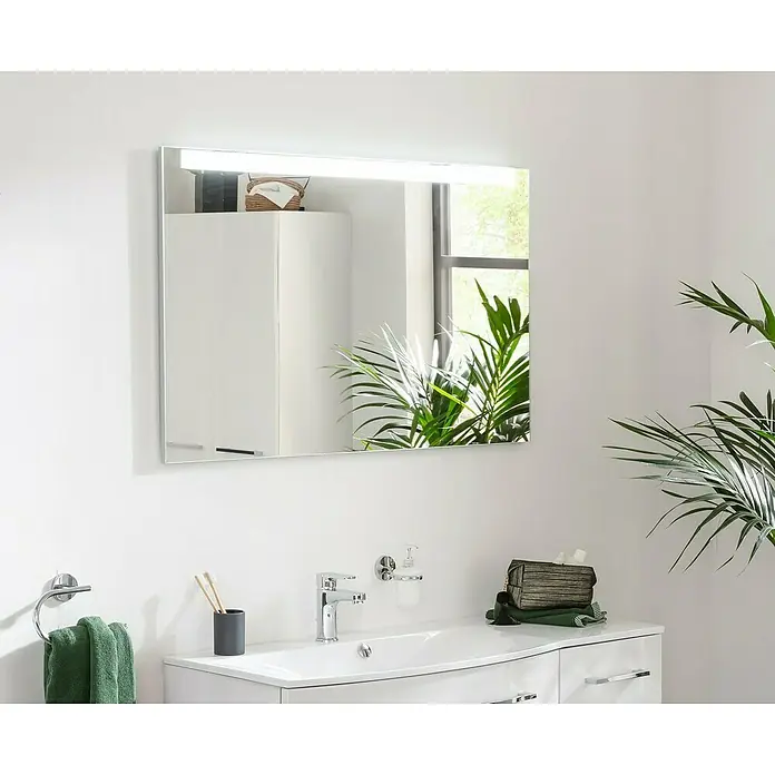 Fackelmann Mirrors LED-Lichtspiegel - 110 x 68 cm, Einfacher Anschluss über Schraubklemme, Rechteckig - Das Foto zeigt einen rechteckigen Spiegel mit LED-Beleuchtung, der über einem weißen Waschbecken in einem Badezimmer hängt.