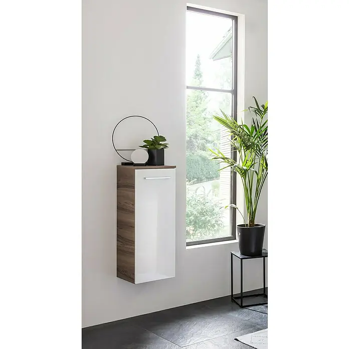 Fackelmann Verona Midischrank - B x T x H: 30,2 x 32 x 82,6 cm, DIN Anschlag: Links, Weiß Hochglanz/Nussbaum - Modernes Badezimmer mit hängendem Holzschrank und weißer Tür, dekoriert mit Pflanzen und stilvollem Accessoire für ein elegantes Ambiente.