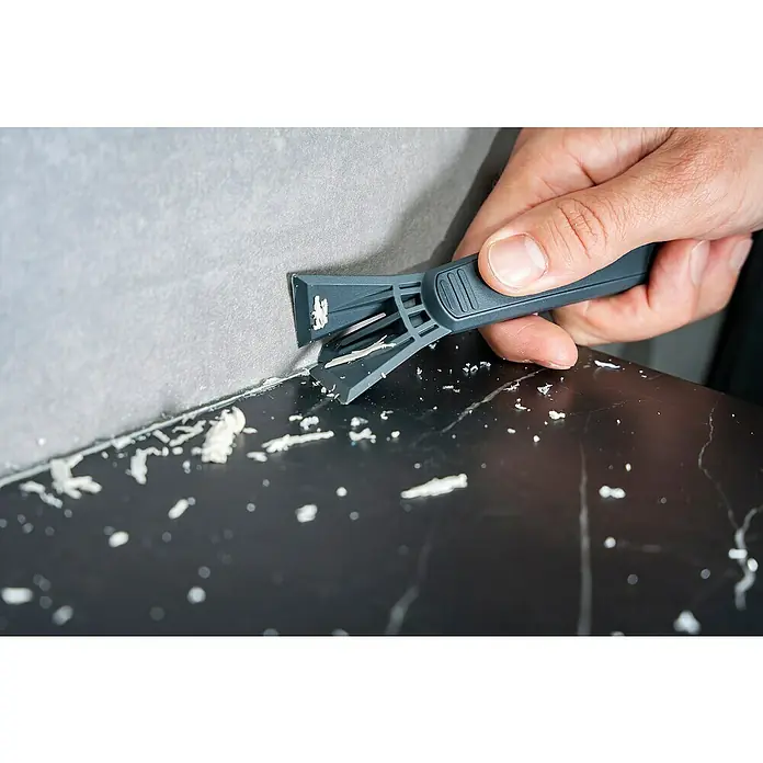 Wolfcraft Rascador de juntas - 4 pzs. - Se está utilizando una herramienta para quitar la masilla para raspar el exceso de material de una superficie y alisar.