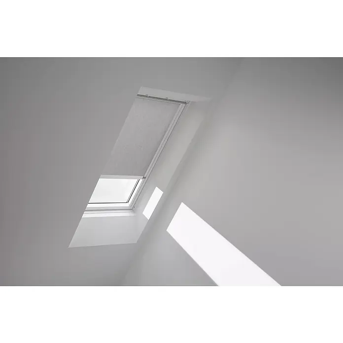 Velux Dachfensterrollo RML CK06 4161KWL - Farbe: Grau - 4161KWL, Farbe Schiene: Weiß, Elektrisch - Helle Innenaufnahme eines Dachfensters mit Rollo, das teilweise geschlossen ist und Licht ins Zimmer lässt.