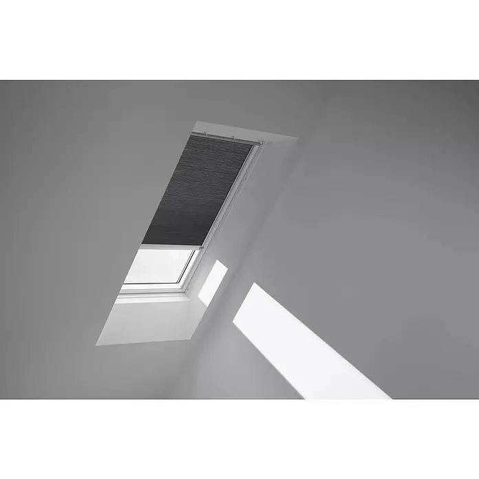 Velux Dachfensterplissee FMC MK04 1170K - Farbe: Grautaupe - 1170K, Farbe Schiene: Aluminium, Elektrisch - Ein Dachfenster mit einem halb geschlossenen, grauen Plissee, das das einfallende Licht teilweise blockiert und eine interessante Lichtwirkung im Raum erzeugt.
