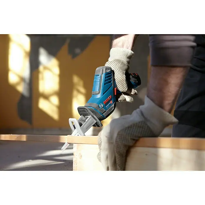 Bosch Professional Akku-Säbelsäge GSA 12V-14 L-Boxx - 12 V, Ohne Akku, Leerlaufhubzahl: 0 /min - 3.000 /min - Nahaufnahme einer Bosch Akku-Säbelsäge beim Schneiden eines Holzstücks, geführt von einer Person mit Arbeitshandschuhen.