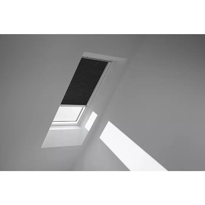 Velux Dachfensterplissee FMC SK06 1047K - Farbe: Graphit - 1047K, Farbe Schiene: Aluminium, Elektrisch - Ansicht eines Dachfensters mit einem Rollo, das teilweise heruntergelassen ist und Licht ins Zimmer lässt.