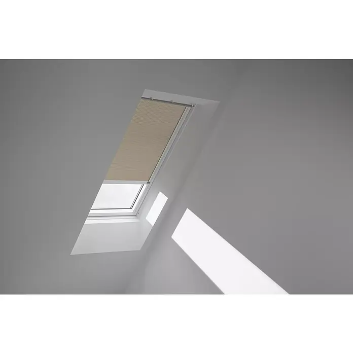 Velux Dachfensterplissee FSC C02 1155KWL - Farbe: Beige - 1155KWL, Farbe Schiene: Weiß, Solarbetrieben - Nahaufnahme eines Dachfensters mit teilweise geschlossenem Rollo, das sanftes Licht in den Raum lässt.