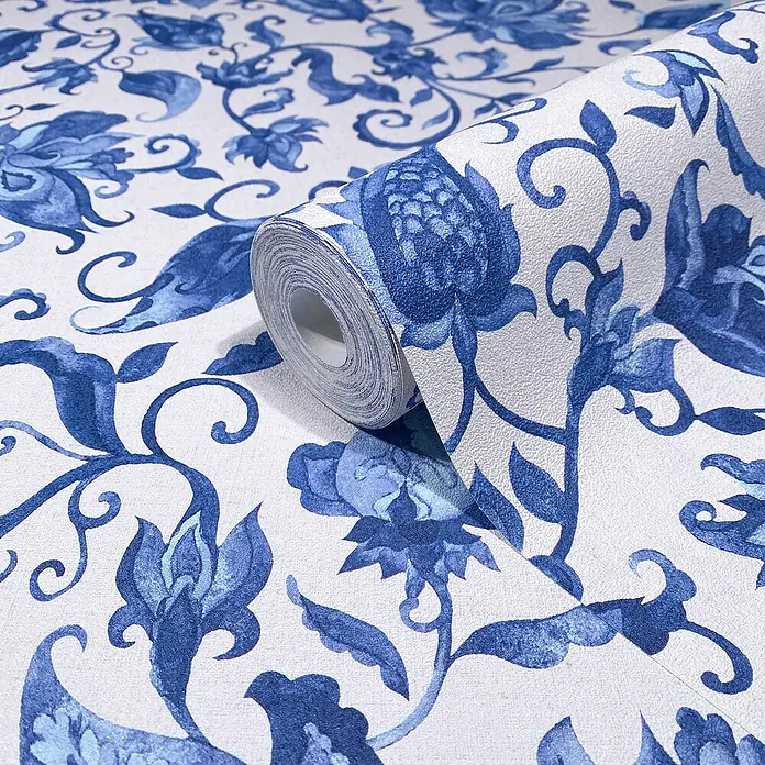 Glööckler Pompöös Provence Vliestapete - Grau/Blau, Floral, 10,05 x 0,53 m - Nahaufnahme einer Rolle blauer und weißer Blumen-Tapete. Ein florales Muster ziert diese hochwertige Wandbekleidung für stilvolle Innenräume.