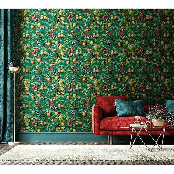 Glööckler Pompöös Provence Vliestapete - Grün/Orange, Floral, 10,05 x 0,53 m - Ein Wohnzimmer mit einer roten Couch, einem goldenen Tisch und einer grünen Wand mit Obstmuster.