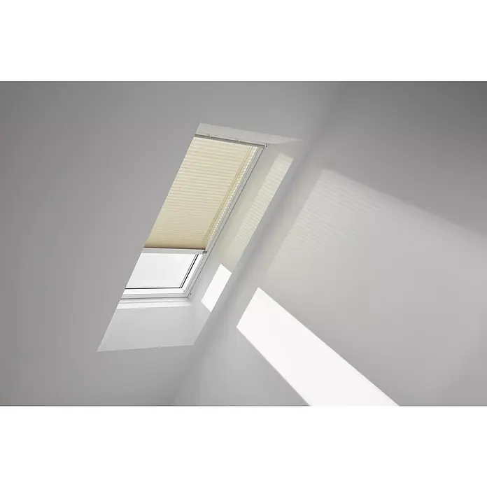 Velux Dachfensterplissee FSL MK06 1277KWL - Farbe: Sandbeige - 1277KWL, Farbe Schiene: Weiß, Solarbetrieben - Dachfenster mit beigefarbenem Plissee in einem hellen Raum, das das einfallende Sonnenlicht sanft filtert und für eine angenehme Atmosphäre sorgt.