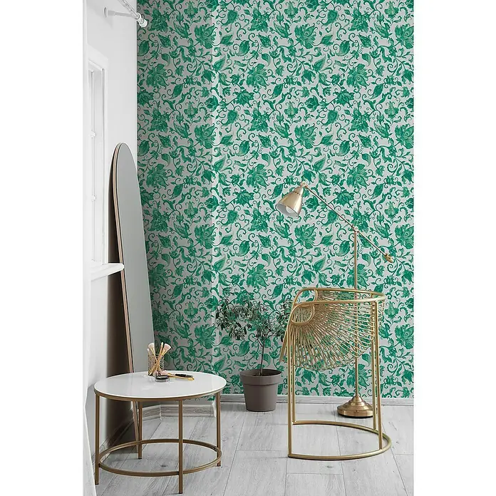 Glööckler Pompöös Provence Vliestapete - Grau/Grün, Floral, 10,05 x 0,53 m - Eine stilvolle Szene mit einem goldenen Stuhl, einem runden Tisch und einem schlanken Spiegel vor einer grünen floralen Tapete.