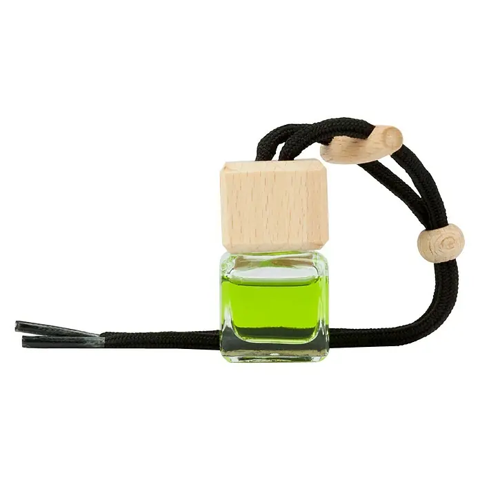 Ambientador de coche para colgar - Manzana, 8 sem. - Se ve un ambientador de coche cuadrado con tapa de madera y cordón negro que contiene una fragancia verde brillante sobre un fondo negro.