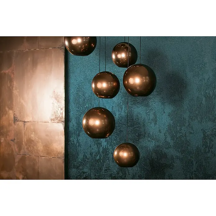 Glööckler Pompöös Provence Vliestapete - Grün/Blau, Metalloptik, 10,05 x 0,53 m - Eine Gruppe von sechs kugelförmigen Pendelleuchten aus glänzendem Kupfer hängen vor einer strukturierten Wand.