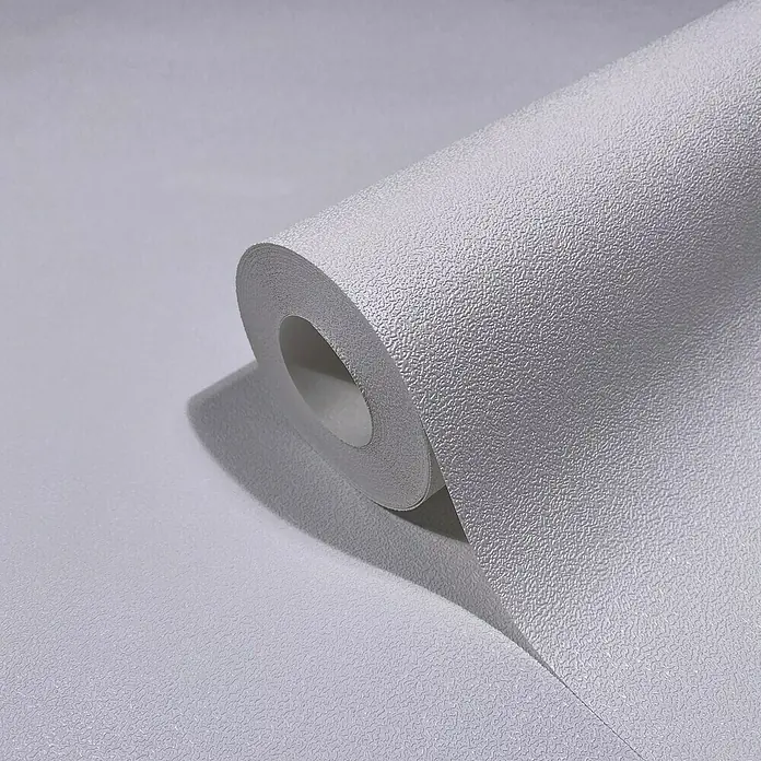 Glööckler Pompöös Provence Vliestapete - Grauweiß, Uni, 10,05 x 0,53 m - Nahaufnahme einer Rolle grauer, strukturierter Tapete, die das Muster und die Textur des Produkts hervorhebt.