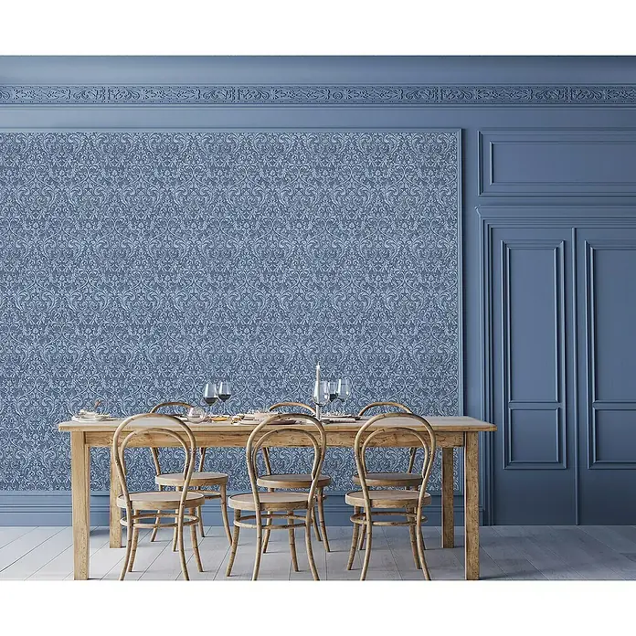 Glööckler Pompöös Provence Vliestapete - Blau/Schwarz, Ornament, 10,05 x 0,53 m - Das Bild zeigt einen Esstisch mit Holzstühlen in einem blau gestalteten Raum mit gemusterter Tapete.