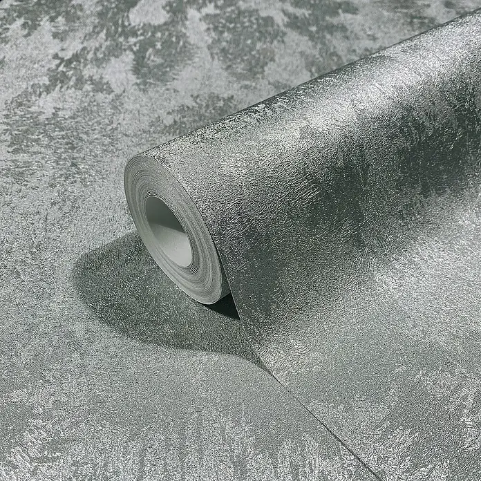 Glööckler Pompöös Provence Vliestapete - Silber, Metalloptik, 10,05 x 0,53 m - Eine Rolle silberfarbene Tapete mit einer leicht strukturierten Oberfläche liegt auf einer gleichfarbigen Fläche. Ideal für moderne Interieurs.