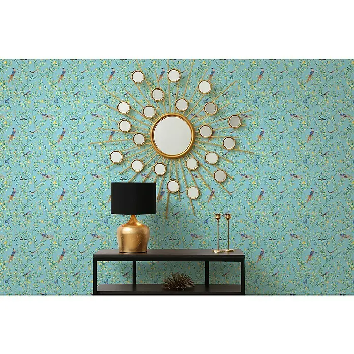 Glööckler Pompöös Provence Vliestapete - Blau/Grün/Gelb, Floral, 10,05 x 0,53 m - Elegante Inneneinrichtung mit einem dekorativen Spiegel, einer stilvollen Lampe und goldenen Kerzenständern auf einem schwarzen Tisch.