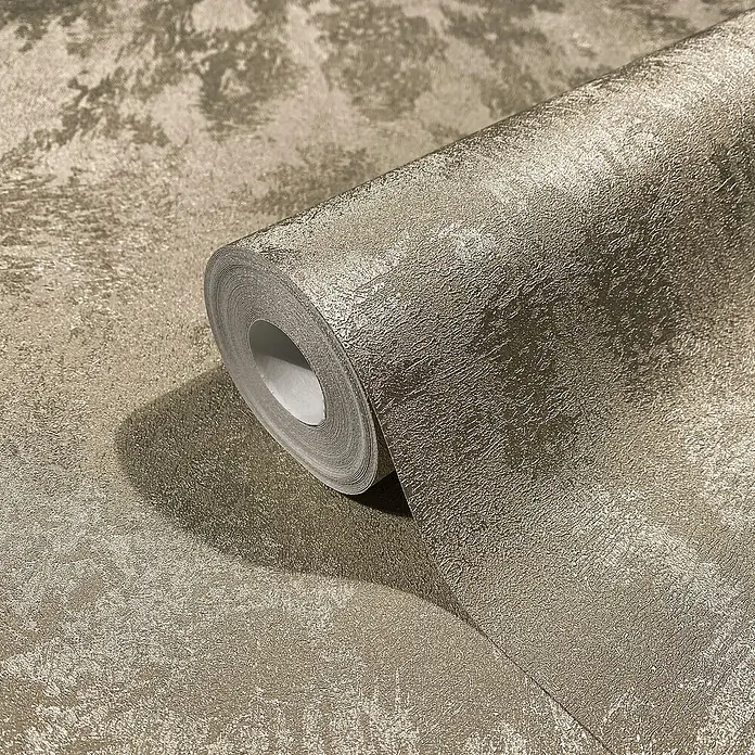Glööckler Pompöös Provence Vliestapete - Platin, Metalloptik, 10,05 x 0,53 m - Nahaufnahme einer Rolle goldfarbener Struktur Tapete, die eine elegante und hochwertige Wandgestaltung verspricht.