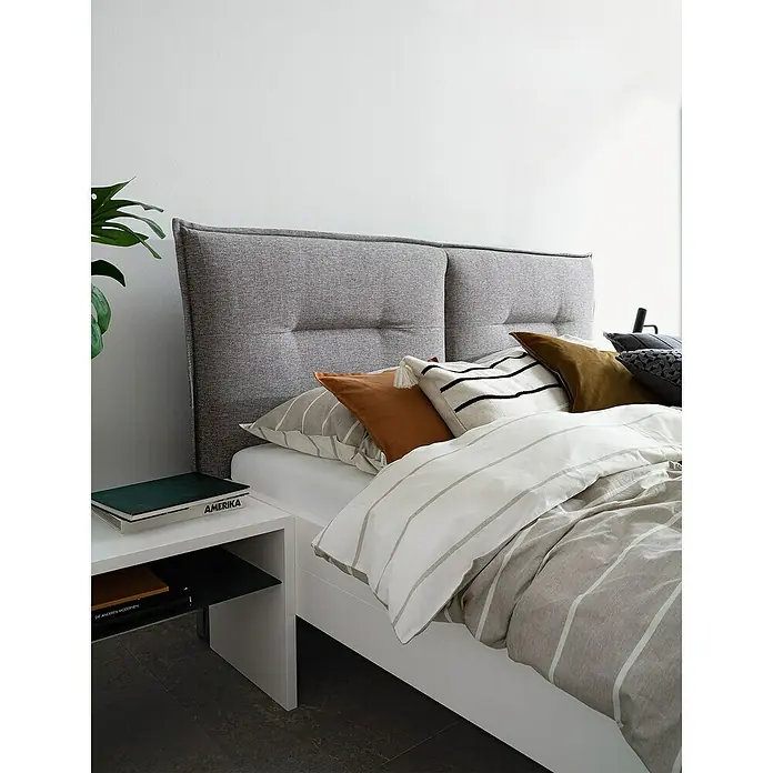 Glööckler Pompöös Provence Vliestapete - Grauweiß, Uni, 10,05 x 0,53 m - Ein stilvolles Schlafzimmer mit einem grauen Stoffkopfteil, das einen Hauch von Eleganz und Komfort in den Raum bringt.