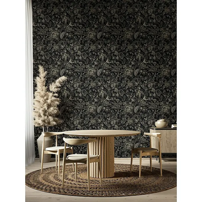 Glööckler Pompöös Provence Vliestapete - Schwarz/Beige, Floral, 10,05 x 0,53 m - Esszimmer mit rundem Holztisch und Stühlen auf einem gemusterten Teppich vor einer floralen Tapete.